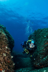Fototapeta na wymiar woman scuba diving over rocks in the Mediterranean Sea