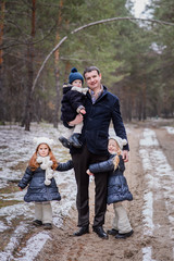 The family is resting in the forest. People stroll in the winter forest