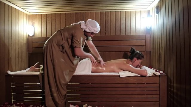Beautiful young woman relaxing with hand massage at beauty spa
