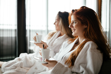 Obraz na płótnie Canvas Women in bathrobes enjoying tea