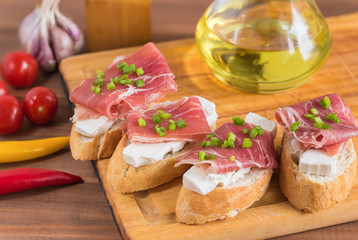 Italian prosciutto and cheese bruschetta. Antipasti on grilled baguette bread.