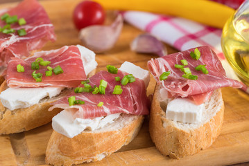 Italian prosciutto and cheese bruschetta. Antipasti on grilled baguette bread.