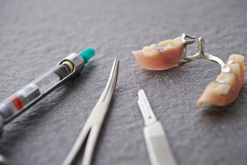 False tooth with dental tools