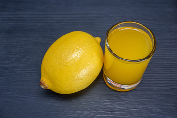 lemon and lemon juice on a dark wooden background