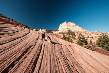 Woman sitting on rock formation in Utah, USA