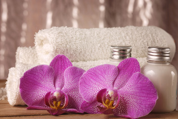 Spa kit with lotions for skin, orchid flowers and white towels