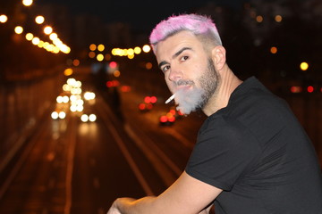 Fototapeta premium Alternative looking male smoking in the city