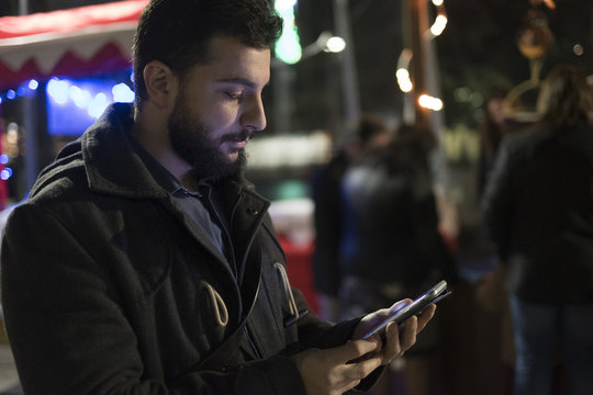Man sending and looking social network messages  in the city