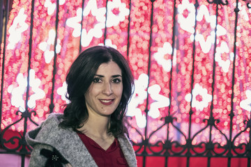 woman portrait with night christmas lights in background