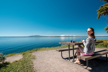 Woman tourist having a breakfast by Yellowstone Lake