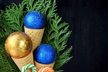 Christmas balls in waffle cones. Thuja branches in the background. Copy space