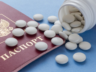 Russian passport and white round tablets. Sports doping, anabolic drugs, pills and tablets. Vitamins