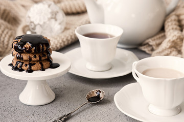 Close-up of white cups of coffee with milk and chocolate cookies on table in vintage style background