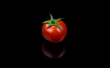 Fresh cherry tomato single on black background