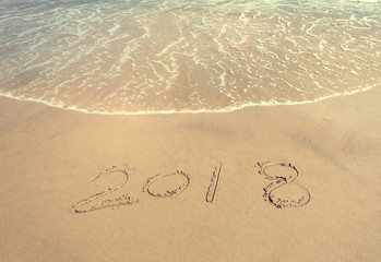 2018 written in sand write on tropical beach