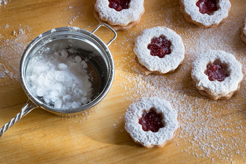 Dusting traditional Linzer Christmas cookies with sugar