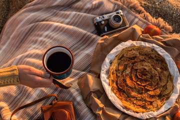 Outdoor picnic with female hand holding a cup of tea