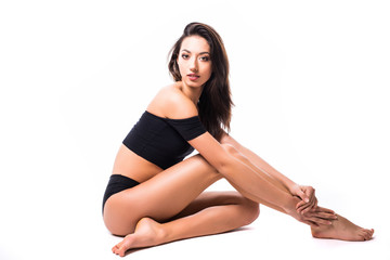 Fototapeta na wymiar Fit and sporty girl in black underwear on the floor. Beautiful and healthy woman posing over isolated white background. Sport, fitness, diet, weight loss and healthcare concept.