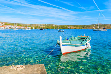 Fototapeta na wymiar Fishing boat mooring on sea shore in Primosten town, Dalmatia, Croatia