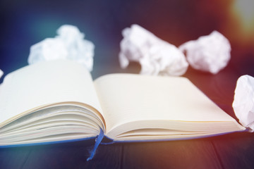 White note pad on a wooden table. Writing concept - crumpled up paper wads with Notepad