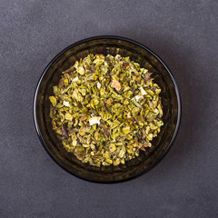 Green paprika spice in a bowl on a grey concrete background