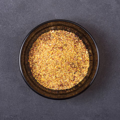 Spice mix - paprika, dried onions, white mustard, caraway seeds, black pepper in a bowl on a grey concrete background