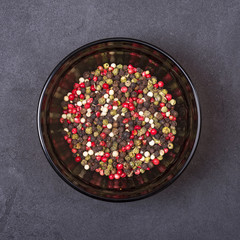 Pepper mix in a bowl on a grey concrete background