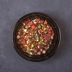 Peppers mix in a bowl on a grey concrete background