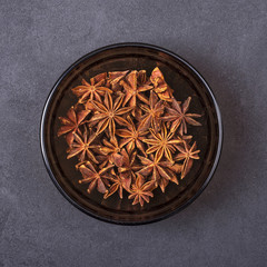 Anise spice in a bowl on a grey concrete background