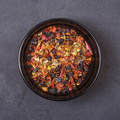 Spice mix - paprika, barberry, saffron, cumin, marjoram in a bowl on a grey concrete background