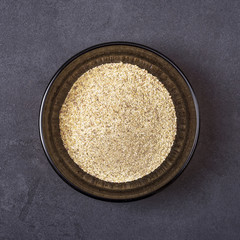 Spice mix - garlic in granules, black pepper, basil, salt in a bowl on a grey concrete background