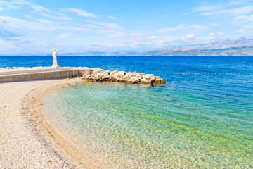 Fototapeta premium View of beach with turquoise sea water in Postira village, Brac island, Croatia