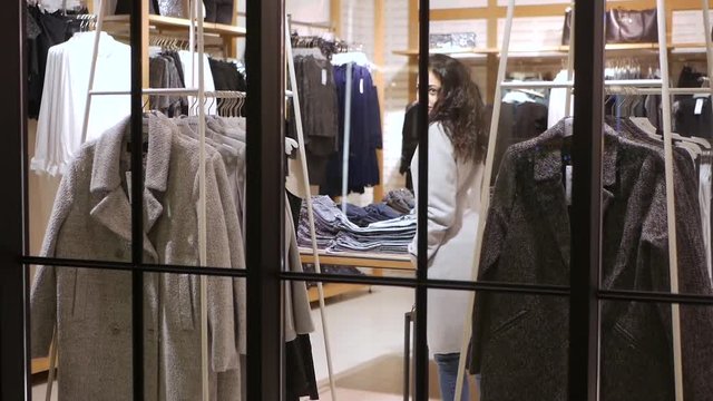 Attractive young woman try clothes in fashion shop