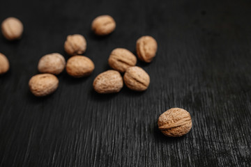 Lots of fresh nuts on a black wooden background. Best practices for designer