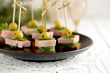 Canapé with rye bread, ham, cucumber and olives. Healthy snack.
