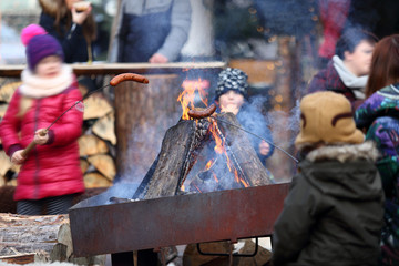 Dzieci pieką kiełbaski nad ogniskiem. - obrazy, fototapety, plakaty