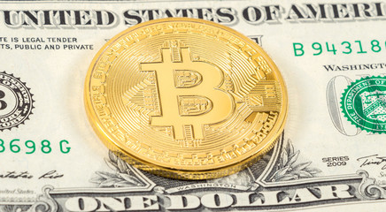 Cryptocurrency of the Bitcoin lying on the american dollar banknote. Business concept of new virtual money