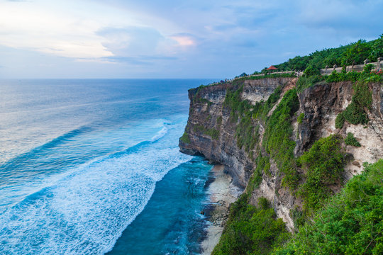 Beautiful view of Uluwatu temple and ocean rocky cliff on sunset. Scenic landscape of fantastic view. Bali, Indonesia.