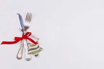 Christmas table place setting with cutlery, pine branch and ribbon. Winter holidays and festive background. Christmas eve dinner, New Year food lunch. View from above, top, horizontal