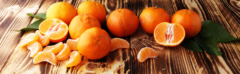 fresh mandarin oranges fruit with leaves on wooden table.