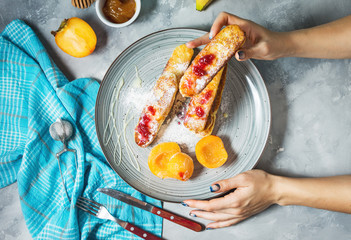 Cottage cheese pancakes with oats, woman hands hold syrniki on concrete background