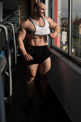 Fototapeta na wymiar Bodybuilder Taking His Shirt Off After Training