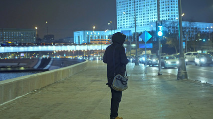 Fototapeta premium man walks near the road in night city streets 