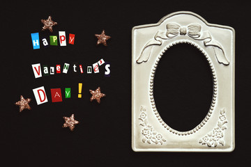 Text happy Valentine`s day made with carved letters, stars shape and old metallic picture frame 
