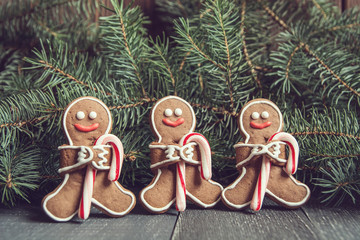 Gingerbread men with candy cane snowflakes laying on grey wood background. Christmas or New Year composition. Christmas card.