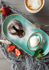 beautiful dessert - chocolate fondant with an ice cream ball with a cup of coffee and strawberries - 184101048