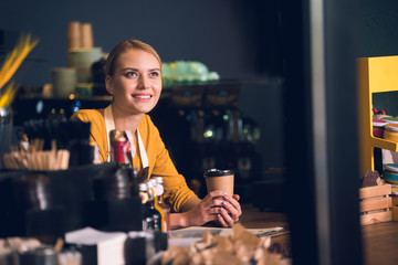 Portrait of pensive female barista drinking cup of delicious coffee while relaxing during job in cafe. Labor concept