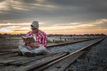 Fototapeta premium Young boy with red shirt and yellow boots in sunset