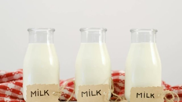 three milk bottles on white background Slide shot from top. Copyspace concept