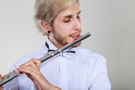 Male flutist playing his flute